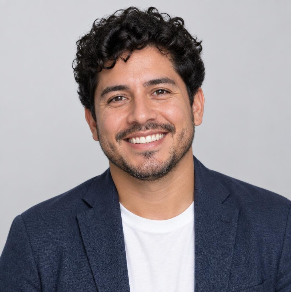 Studio portrait of a man with curly hair smiling
